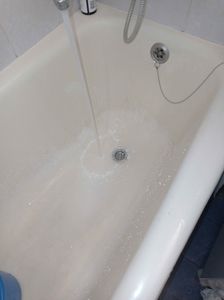 Ванна очищена от засора, вода свободно уходит в слив. Поверхность чистая, без следов загрязнений. Трубы промыты, обеспечена нормальная проходимость. Работы завершены успешно.