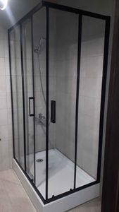 Установлена конструкция из стекла с металлическими рамами, закреплены панели, подключен смеситель, герметизация швов, проверка герметичности, завершение монтажа поддона.