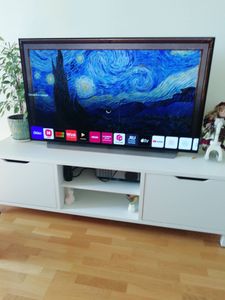 Экран аккуратно установлен на тумбу, подключены все необходимые кабели, проверена работоспособность устройства, изображение отображается корректно, обеспечена устойчивость конструкции.