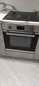 На изображении установлена варочная панель и духовой шкаф в кухонный гарнитур. Поверхность подключена к электросети, все элементы встроены и готовы к использованию.