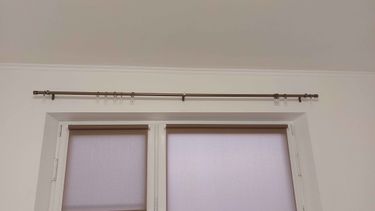 Закреплен металлический профиль над оконным проемом, обеспечивающий надежное крепление для штор. Установлены кронштейны, равномерно распределяющие нагрузку.