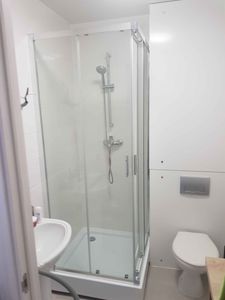 Установлена стеклянная кабина с раздвижными дверцами, смонтирован поддон, подключены водопроводные коммуникации, закреплены панели, проверена герметичность соединений.