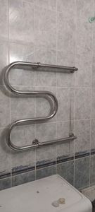 Монтаж завершён: закреплён новый водяной полотенцесушитель на кафельной стене, подключены трубы, проверена герметичность соединений, обеспечена надёжная фиксация.