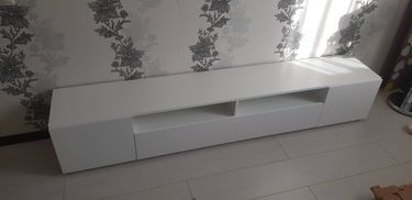 Собрана новая мебель: установлены панели, закреплены полки, выдвижные ящики на месте. Конструкция выровнена, все элементы надежно соединены, поверхность чистая, готова к использованию.