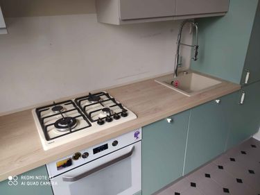 Установлена новая столешница из ДСП, выполнены вырезы под варочную панель и мойку, закреплены все элементы, подключены коммуникации, обеспечена ровная поверхность и аккуратные стыки.