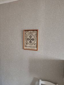 На стене закреплено декоративное панно в деревянной раме, выполнено аккуратно и надежно, обеспечивая эстетичный вид и гармоничное дополнение интерьера.