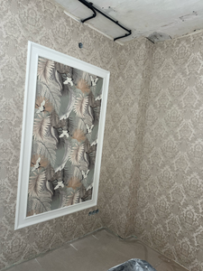 Стены оклеены изысканными обоями с узором, центральная часть выделена контрастной вставкой в рамке, создавая элегантный акцент. Поверхности ровные, стыки аккуратные.