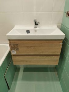 Установлена раковина с тумбой, подключен смеситель и слив. Проведены работы по герметизации и проверке соединений на герметичность. Компактное размещение в ванной комнате.