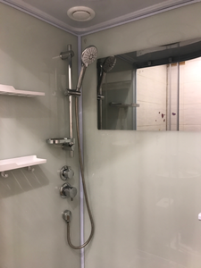 Установлены стеклянные панели, закреплены дверцы, подключены смеситель и лейка, герметизированы швы, смонтирован поддон, проверена герметичность, установлены полки и зеркало.