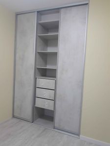 Собран шкаф с полками и выдвижными ящиками, установлены раздвижные двери. Конструкция выполнена аккуратно, обеспечивая функциональность и стильный внешний вид.