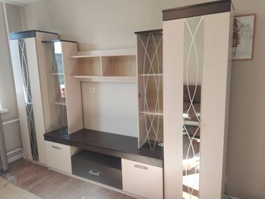 Собрана мебель: установлены полки, закреплены дверцы, прикреплены ручки. Все элементы тщательно выровнены и зафиксированы, обеспечивая устойчивость и функциональность конструкции.