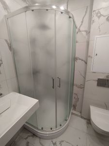 Установлена душевая кабина с полукруглыми матовыми стеклянными дверцами на поддоне, закреплена фурнитура, герметизация швов, подключение к водопроводу, проверка функциональности.