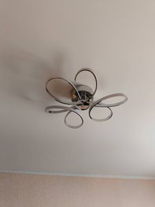 Установлен современный потолочный светильник с оригинальным дизайном, обеспечивающий равномерное освещение. Выполнено подключение к электросети, проверена работоспособность.