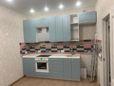 Установлена новая поверхность из искусственного камня, идеально подогнанная под кухонный гарнитур, с вырезами для мойки и плиты, обеспечивая современный и функциональный вид помещения.