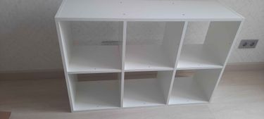 Собрано изделие из шести секций, установлены полки, закреплены боковые панели, прикреплена задняя стенка. Все детали соединены, конструкция устойчива, готова к использованию.