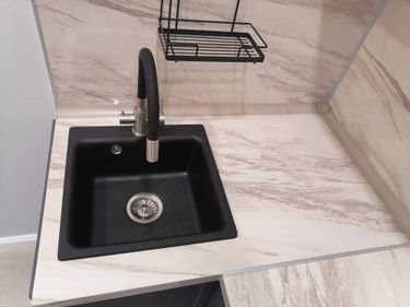 Под раковиной смонтировано устройство для переработки остатков пищи. Подключены водопровод и электричество. Проверена работоспособность, выполнена герметизация соединений.