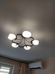 Установлена новая люстра на потолок, подключены провода, проверена работоспособность освещения, закреплены все элементы, обеспечена надежная фиксация конструкции, протестировано включение.