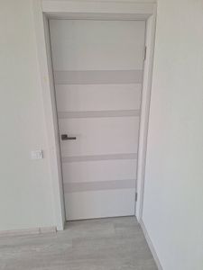 Установлена новая дверь, закреплены петли, врезана ручка, отрегулировано полотно, проверена плавность закрывания, выполнена отделка откосов, обеспечена герметичность и шумоизоляция.