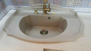 Установлена столешница из искусственного камня с раковиной и смесителем. Все элементы аккуратно подогнаны, швы герметично заделаны, поверхность ровная и гладкая, обеспечена надежная фиксация.