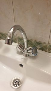 Установлен новый хромированный кран на раковину, подключены водопроводные трубы, проверена герметичность соединений, обеспечена функциональность и отсутствие протечек.