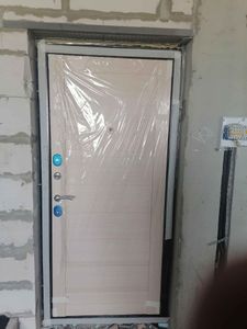 Установлена новая дверь с замком и ручкой. Проведена герметизация проема, произведена отделка откосов, проверена работа механизма. Защитная пленка оставлена для сохранности.