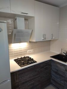 Завершена установка новой поверхности из искусственного материала на кухне, включая вырезы для варочной панели и мойки, с точной подгонкой и аккуратной отделкой.