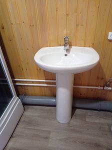 Установлен умывальник с подключением к водопроводу и канализации. Смеситель закреплён, трубы подведены, слив функционирует. Завершена проверка герметичности и работоспособности системы.