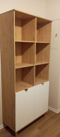 Собрана конструкция с полками и дверцами. Установлены панели, закреплены элементы, обеспечена устойчивость. Завершена сборка, проверена надежность соединений.