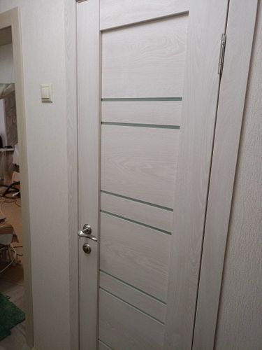 Установлена новая деревянная дверь с одной створкой. Проведены работы по монтажу коробки, навешиванию полотна, закреплению петель и ручки. Все элементы надежно зафиксированы и отрегулированы.