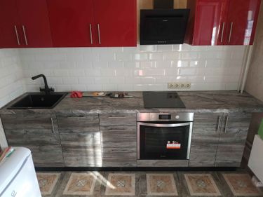 Установлены шкафы, смонтирована столешница из ДСП, врезана варочная панель, подключена мойка, закреплены фасады, установлена вытяжка, подключены розетки, завершена укладка фартука.