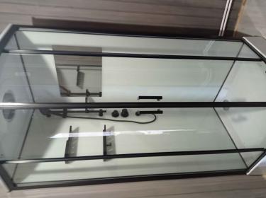 Установлена современная душевая конструкция с низким основанием, герметично закреплены стеклянные панели и дверцы, подключены водопроводные коммуникации, смонтированы полки и смеситель.