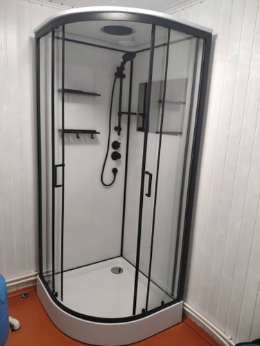 Установлена современная душевая конструкция: закреплены стеклянные панели, смонтирован поддон, подключены водопроводные коммуникации, установлены полки и смеситель, проверена герметичность.