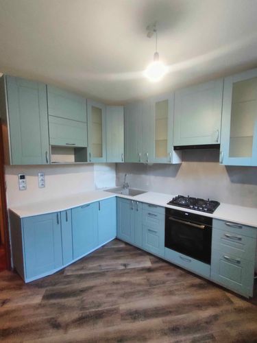 Установлена гладкая поверхность из искусственного камня, подогнана по размерам, закреплена на кухонных шкафах, вырезаны отверстия для мойки и плиты, обработаны края для эстетичного вида.