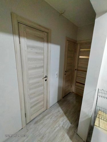 Установлена светлая межкомнатная дверь с фурнитурой, выполнены работы по монтажу коробки и наличников, обеспечена ровная подгонка и плавное открывание.