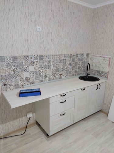 Удалены шкафы, сняты полки, демонтированы столешница и мойка, отключены коммуникации, очищены стены от креплений, освобождена площадь для последующих работ.