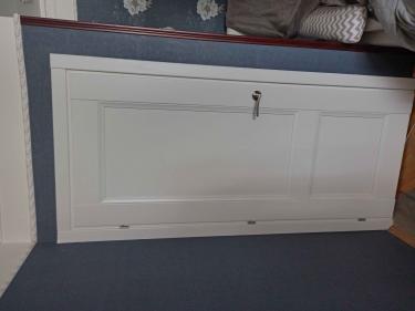 Изображена установленная белая дверь с ручкой и петлями, аккуратно вписанная в дверной проём, гармонирующая с интерьером комнаты.