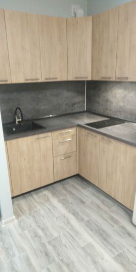 Установлены шкафы, закреплены фасады, смонтирована столешница, подключена мойка, установлена варочная панель. Завершена отделка стен и пола. Всё собрано и готово к использованию.