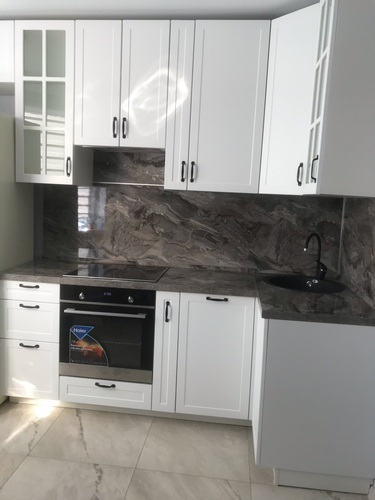 Отрезана и установлена кухонная поверхность, подогнана под размеры, выполнены вырезы для варочной панели и мойки, обеспечена точная подгонка, завершена установка без зазоров.