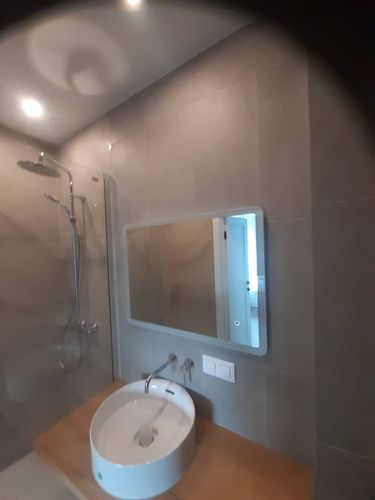 Установлено прямоугольное зеркало над раковиной в ванной комнате. Закреплено на стене с учётом уровня и симметрии, обеспечена надёжность креплений и эстетичность расположения.