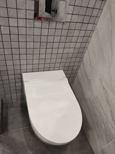 Закреплен сантехнический прибор на стене, подключены водопровод и канализация, установлена кнопка смыва, проверена герметичность соединений, завершена облицовка плиткой.