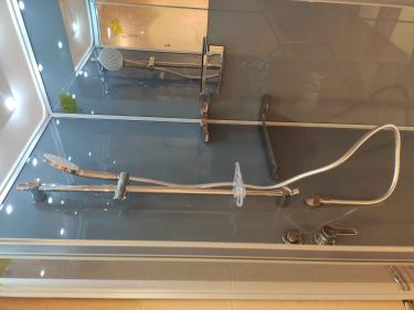 Установлена кабина с низким поддоном: смонтированы стенки, закреплены двери, подключены смеситель и лейка, герметизированы швы, проверена герметичность, установлены полки и держатели.