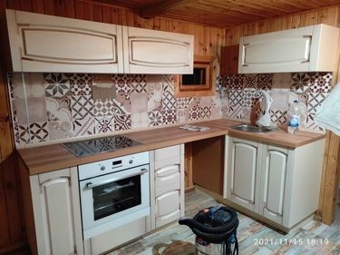 Установлены шкафы, закреплены фасады, смонтирована столешница, встроена варочная панель, подключена мойка. Завершена отделка фартука плиткой с узором.