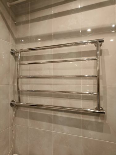 Закреплен новый металлический прибор на стене ванной комнаты, подключен к водопроводной системе, обеспечена герметичность соединений, проверена функциональность и надежность конструкции.