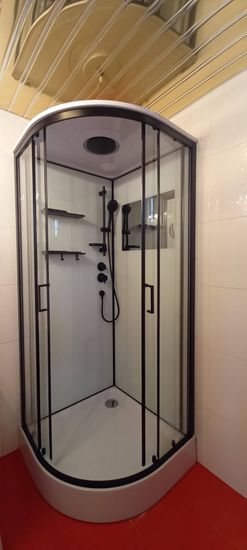 Установлена современная душевая конструкция: закреплены стеклянные панели, смонтирован поддон, подключены смеситель и лейка, герметично зафиксированы швы, проверена функциональность.