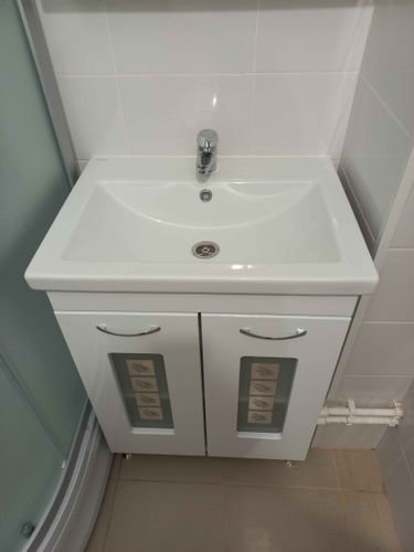 Изображение ванной комнаты с установленной раковиной и смесителем. На стене над раковиной закреплено зеркало, обеспечивающее комфортное использование.