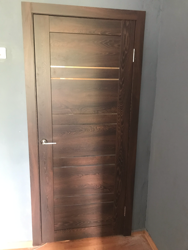 Установлена деревянная конструкция, закреплены петли, врезана ручка, отрегулировано полотно, проверено закрывание, выполнена отделка проема, обеспечена надежная фиксация.