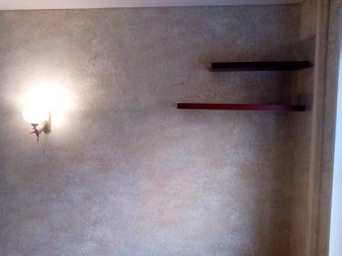 Стены покрыты новыми обоями с текстурным узором, создающими уютную атмосферу. Установлены полки, добавляющие функциональность и стиль. Светильник гармонично вписывается в интерьер.