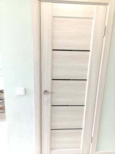 Установлена светлая межкомнатная дверь с одной створкой, закреплена на петлях, врезана ручка, отрегулирована фурнитура, проверена плавность закрытия.