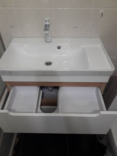 Установлена раковина с подключением к водопроводу и канализации, закреплён смеситель, проверена герметичность соединений, выполнена регулировка выдвижных ящиков.