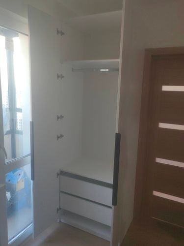 Установлена полка внутри шкафа, закреплена надежно, обеспечивая дополнительное место для хранения. Вся конструкция выровнена и готова к использованию.